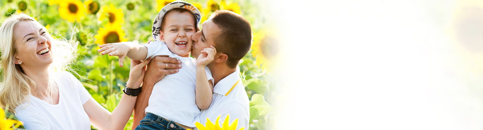 Mom, dad, and child playing in field of sunflowers