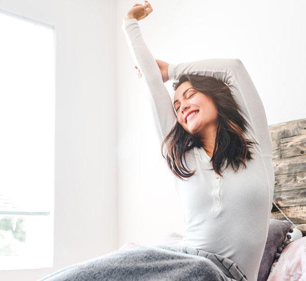 woman stretching in bed