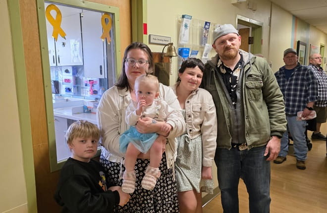 Sophia Erlston ringing the bell to acknowledge her last chemotherapy treatment with her family.