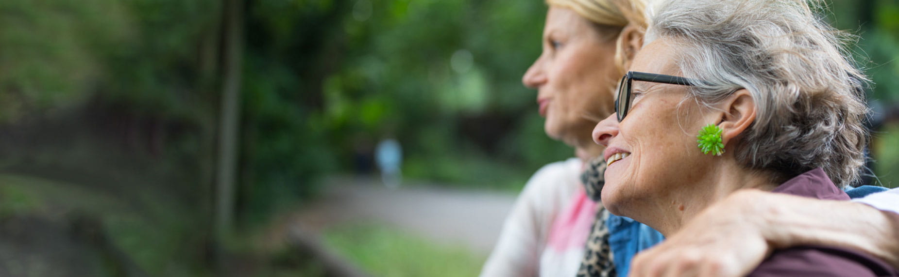 Mid 40s woman and her mother smiling in a park after beating kidney cancer