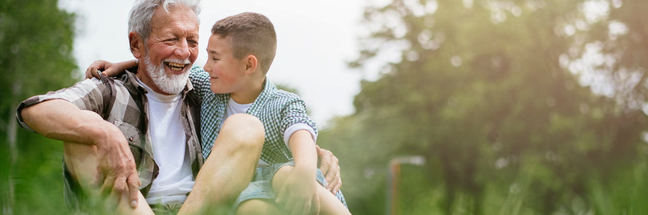Senior man with 10 year old grand son in a field.