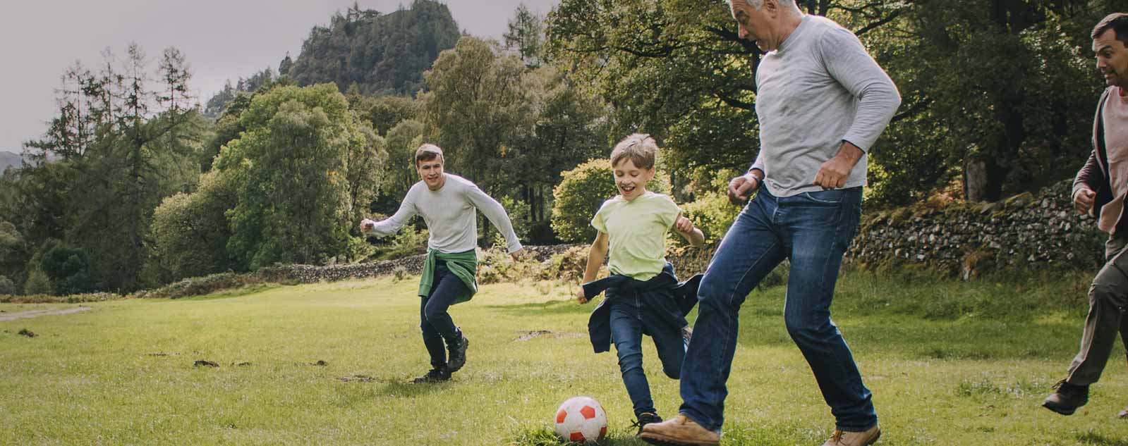 Family in a field playing soccer after working with Geisinger orthopaedic care 