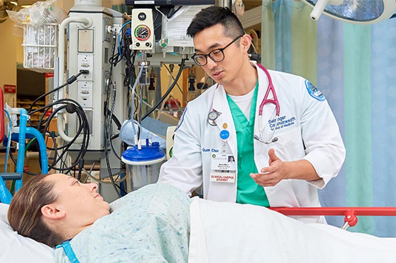 Physician speaking with patient in bed