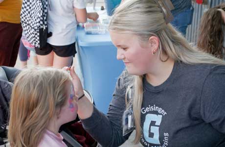 nursing student face painting a child