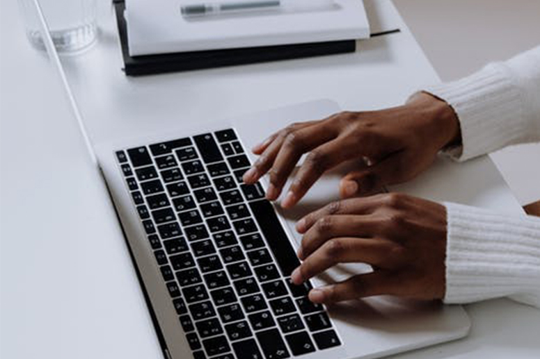 Hands typing on computer