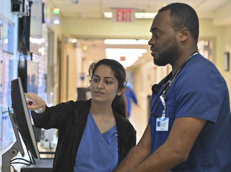 Two medical staff members a man and a woman looking at a computer monitor