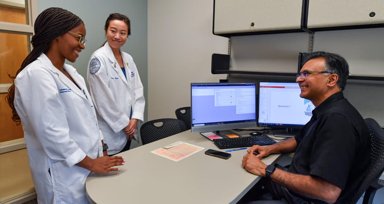 two students talking to staff memeber