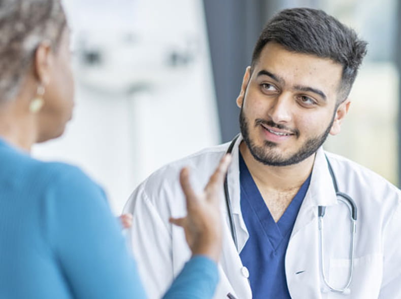 A male doctor talking to a female patient