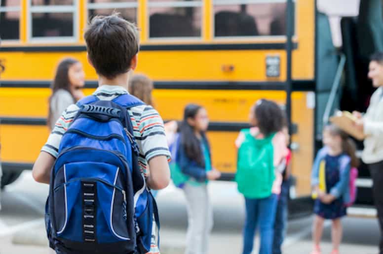 Young children board bus to head back to school.
