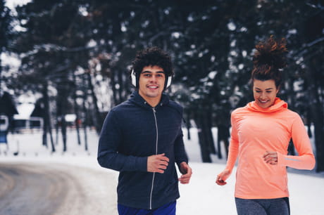 Man and woman running in the winter.