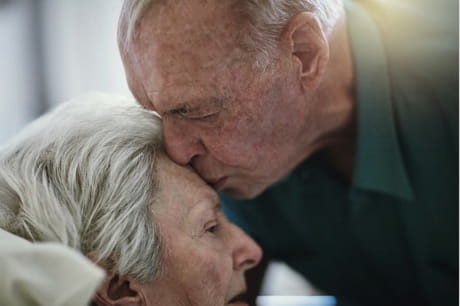 Man kissing woman on the forehead.