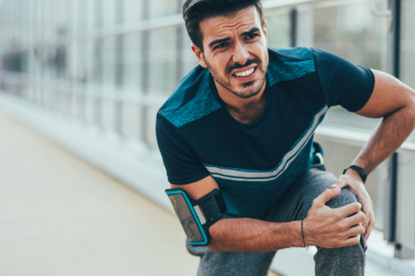 Man clutches knee in pain