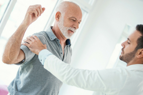 Man with shoulder injury being examined by doctor