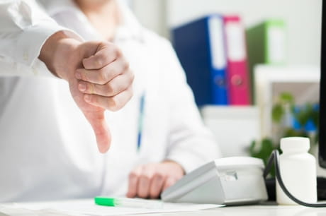 Doctor giving a thumbs down.