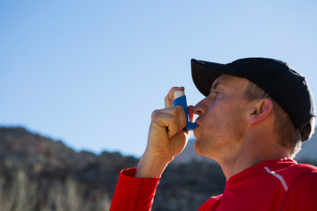 Man breathing into an inhaler