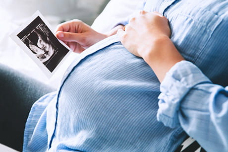 Pregnant woman looking at ultrasound image