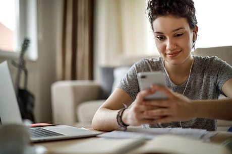 Young teen girl using her smartphone at home.