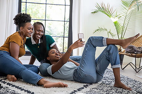 Three young women smiling and taking a photo together.