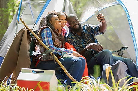 Family camping and taking a selfie.