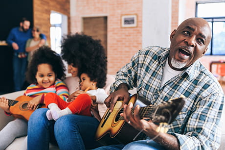 Family sitting on couch singing 