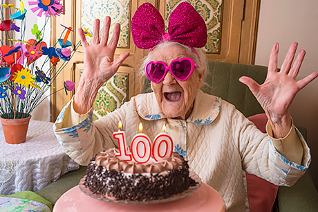 An exuberant elderly woman celebrates her 100th birthday.