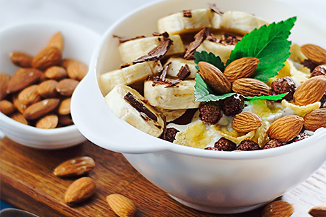 A prepared recipe of chocolate-drizzled fruit cups with almonds.