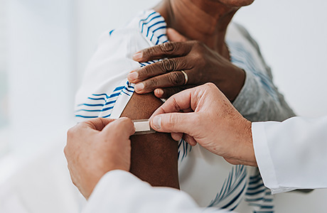 A patient receives a vaccine from the clinic's provider.