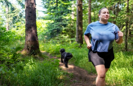 A woman running with a dog.