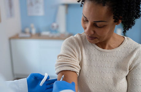 A woman getting a shot at doctors office. 