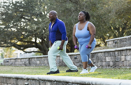 Man and woman doing lunges preparing for weight loss surgery.