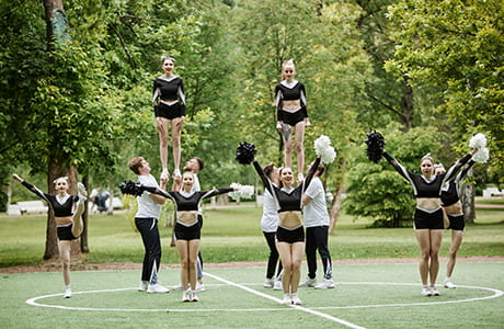 Cheerleading team dancing together at sport competition outdoors