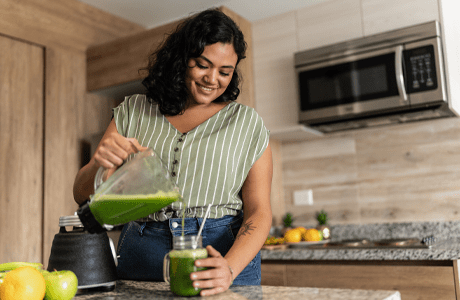 A woman making a healthy drink to help with her PCOS