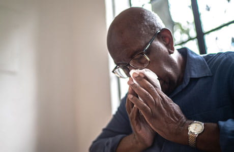A man blowing his nose. 