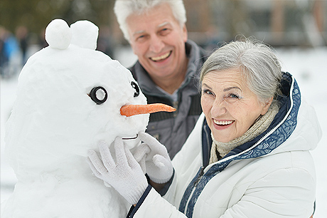 Older couple bundled up on a snowy day outside