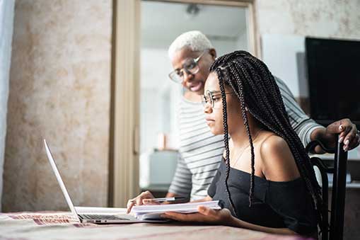 granddaughter on computer showing something to her grandmother