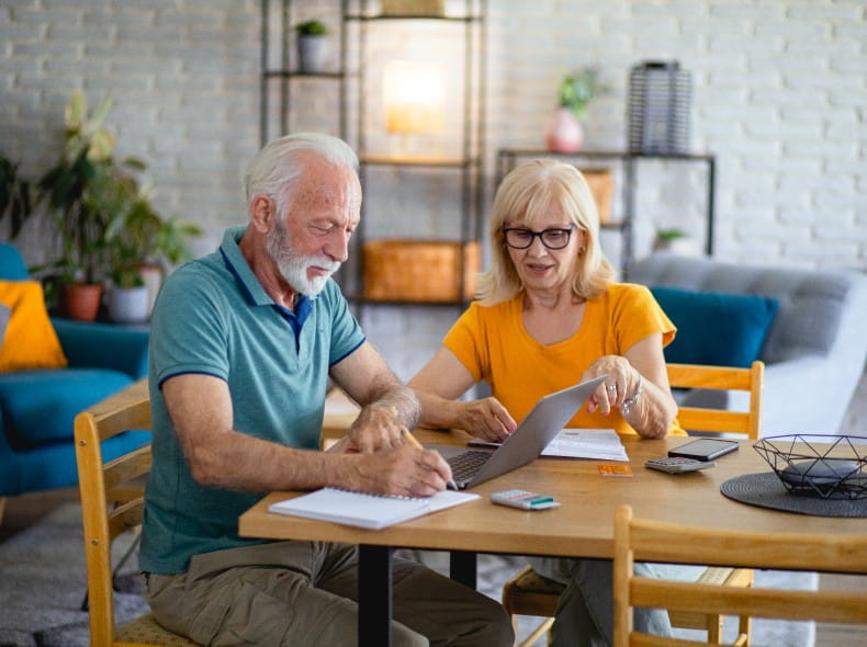 Senior Couple holding a tablet smiling from the ease of paying their bill online at Geisinger.