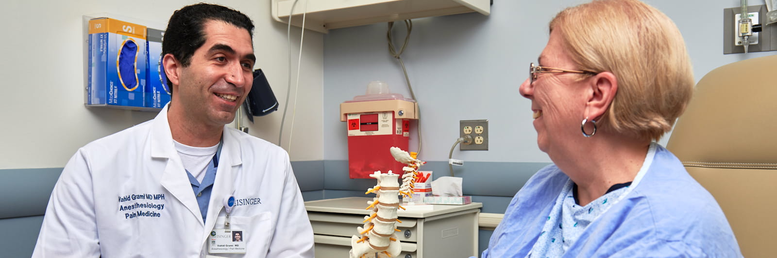 pain clinic doctor with patient and spine