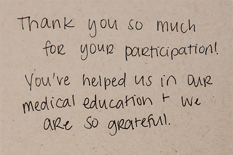 Handwritten thank-you note for participation in medical education on a beige background.
