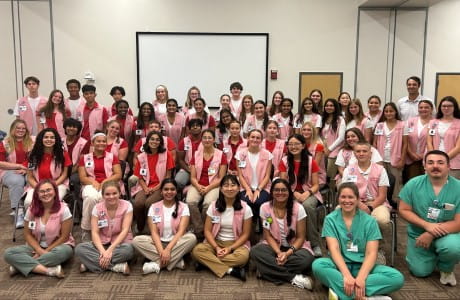 a large group of teen volunteers sit in a conference room