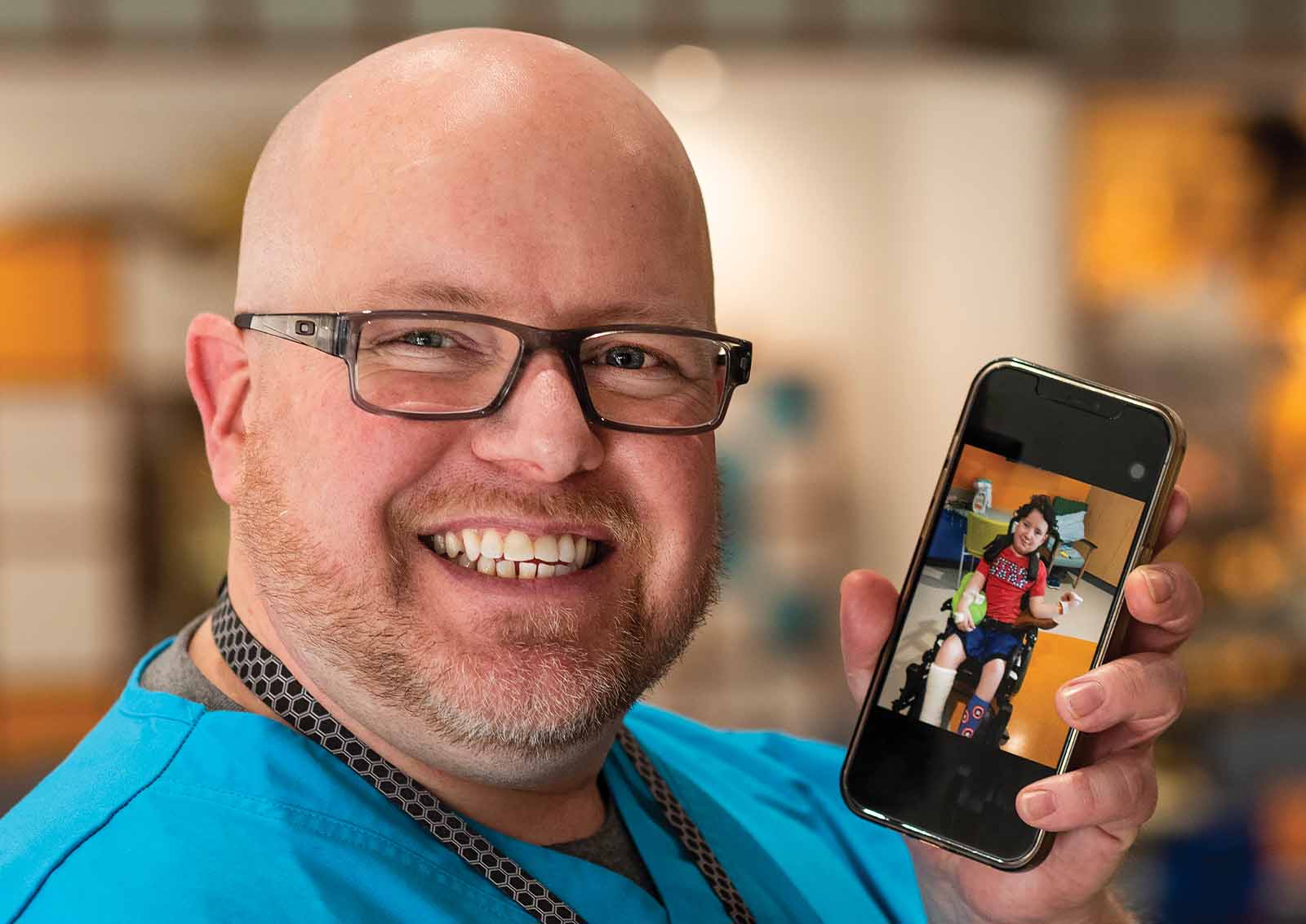 Intern and nursing assistant Joshua Reinsburrow displays a photo of his son.